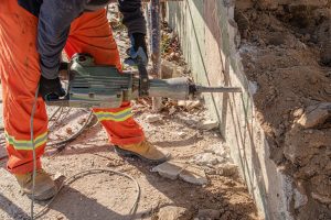 Jack hammer taking a backyard wall remodeling